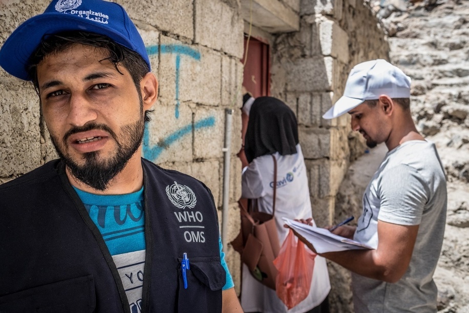 A WHO staff health worker goes door to door with two local health workers during WHO's Oral Cholera Vaccination campaign in Aden, Yemen.