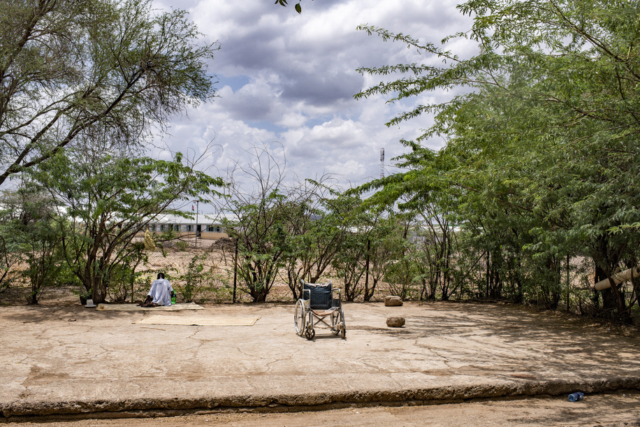 Kakuma, Kenya - 26 March, 2018: Patient and a wheelchair in the backyard of Kakuma Mission Hospital. This hospital in Northern Kenya is one of the few facilities in the region of Turkana where patients can have ophthalmologic consultation and eye related operations.