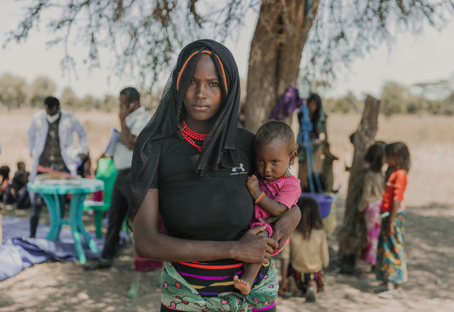 On 19 October 2022, Temira is pictured wtih her 12-month-old daughter Zahara in front of the Eltomale Site Mobile Health and Nutrition Team in Chifra, Afar. 