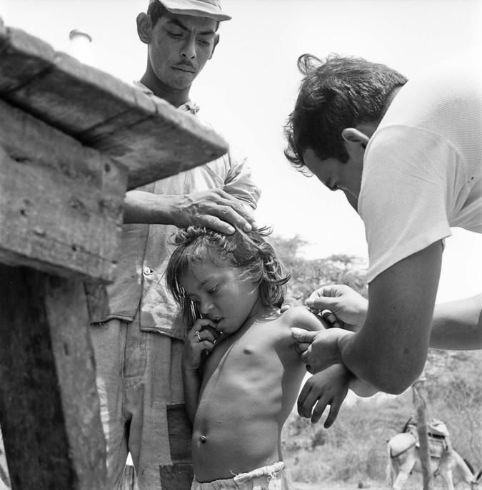 A campaign for the eradication of smallpox in Colombia. A WHO/assisted national team went from village to village and from house to house investigating the state of health of the people and vaccinating the whole population against smallpox. Our photos show the work of the team in the province of Atlantico, a mountainous and arid region near Barranquilla. A little girl being vaccinated.