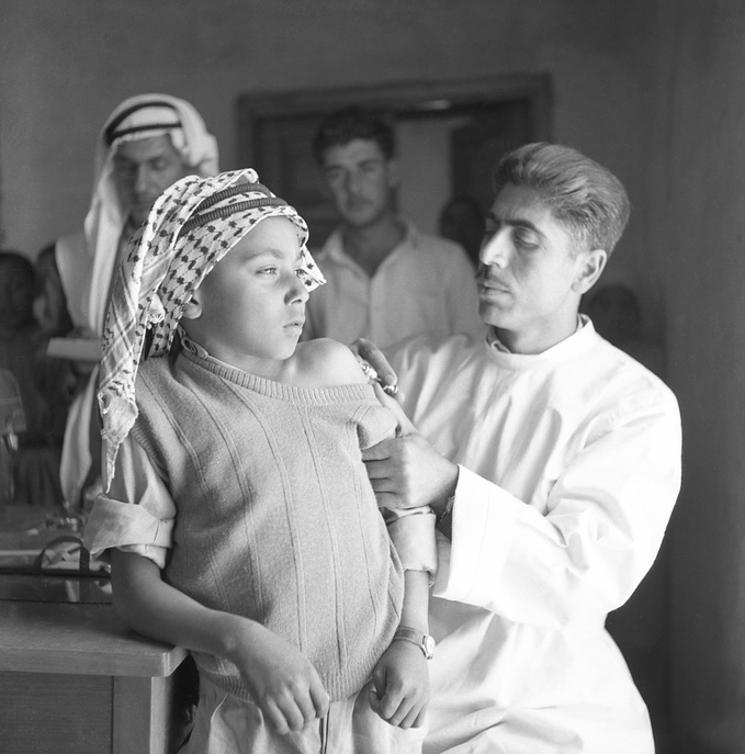 Mr Nicola Awad, vaccinator, is giving BCG to a boy in rural school of Dayat village. c. 1950 - c. 1959