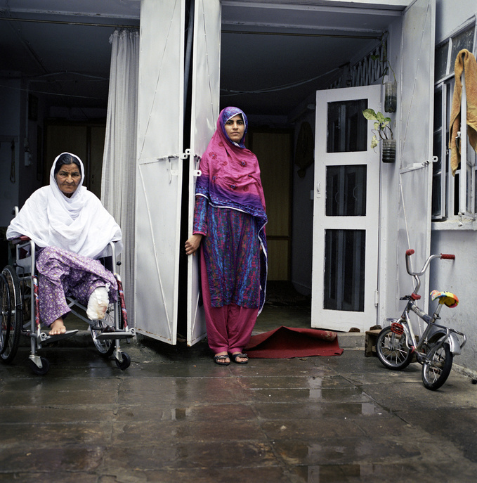 Zahida Bibi (left), 65, sits on a wheelchair with a female family member by her side. This particular feature presents Zahida, who has had diabetes for the past 20 years. For years, she did not know that she had the disease. 