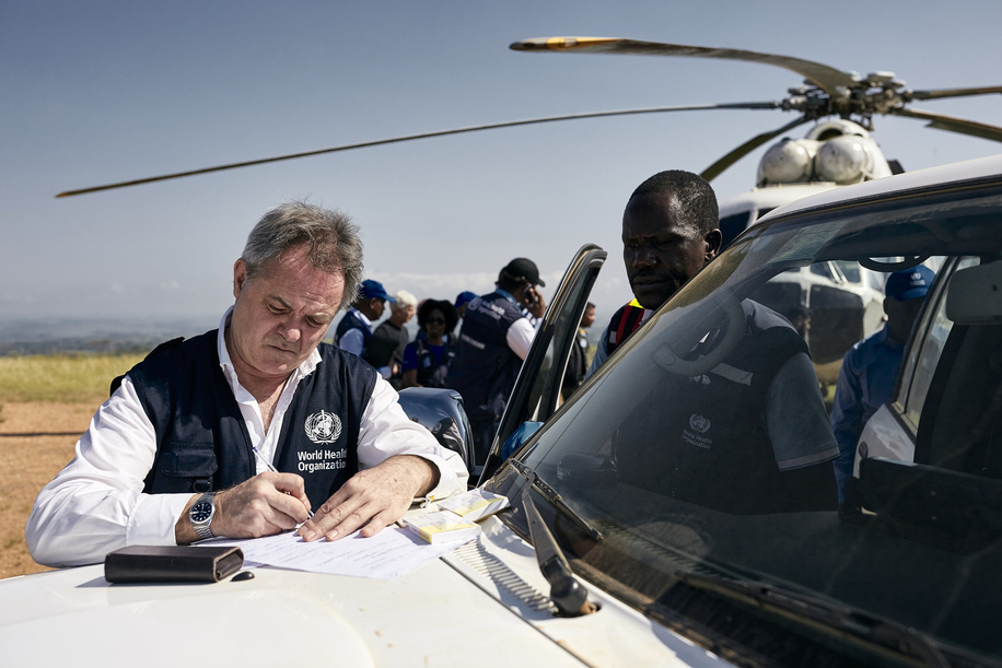 WHO’s response to Ebola virus disease (EVD) outbreak in the Democratic Republic of Congo. Director of the Wellcome Trust and Chair of WHO's Research and Development Blueprint Dr Jeremy Farrar takes notes before getting on a helicopter in Komanda. Komanda is one of the current epicentres of the ongoing Ebola outbreak. WHO Director General Dr Tedros Adhanom Ghebreyesus traveled over the New Year to Ebola-affected areas to review the response at this critical phase. On the three-day mission (31 December 2018 - 2 January 2019) to Beni, Butembo and Komanda, Dr Tedros Adhanom Ghebreyesus took stock of the outbreak, spent time with affected communities, and personally thanked responders for their dedication. WHO has 380 response staff in North Kivu and Ituri working together with hundreds more from the Ministry of Health and partners. Title of WHO staff and officials reflects their respective position at the time the photo was taken.