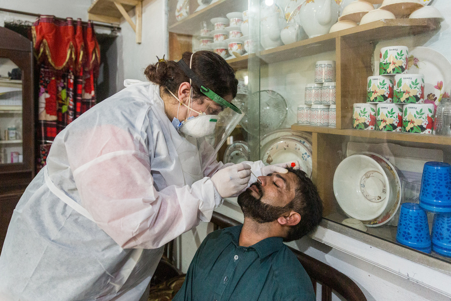 Dr Samreen Khalil, WHO Polio Eradication Officer, collects a sample from Muhammad Shabir at his residence in order to test for COVID-19.
-
Title of WHO staff and officials reflects their respective position at the time the photo was taken.