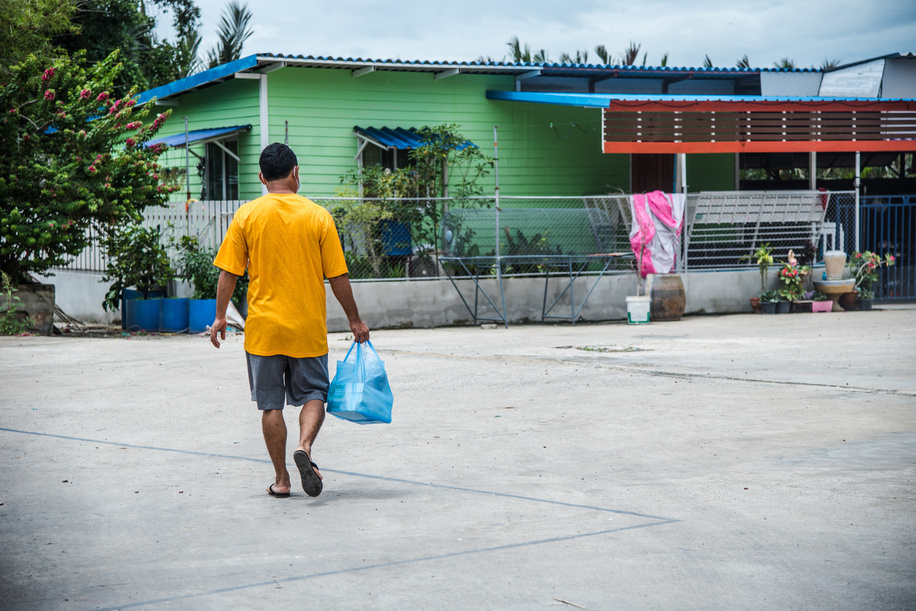 A Burmese dormitory caretaker walks towards the dorms where migrant workers live in Samut Sakhon Province, on 17 June 2020. Thai officials are working to prevent any COVID-19 outbreak in the dorms.