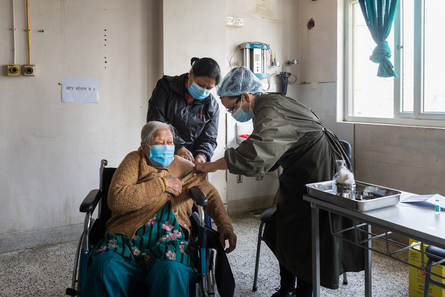 On 12 March 2021, Saraswoti Devi Shrestha (left) receives COVID-19 vaccine at Paropakar Maternity and Women’s Hospital in Kathmandu, Nepal.
