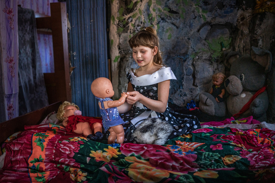 Nadiia Arkhypenko, 9, plays with her dolls during a home visit by members of the WHO-supported mobile mental health team with Nadiia's mother Nataliia Svirhun, 39, a former patient, on February 15, 2021 in Bylbasivka, Ukraine. The COVID-19 pandemic and protracted conflict along the Ukraine-Russian border have had a devastating impact on Ukrainians with severe mental health conditions. These coinciding events have further limited their access to specialized care. Introduced by WHO in 2015, the community mental health teams project originally aimed to provide comprehensive community-based mental health care to people who faced consequences of the conflict. In 2020 WHO has reinforced its support to Ukraine in the area of mental health as a part of WHO Special Initiative for Mental Health, and seven community mental health teams are working across Ukraine during the COVID-19 pandemic. Community-based  care is a new  approach for mental health care in Ukraine but with the support from WHO, Ukraine aims to scale up the teams  for people with severe mental health conditions throughout the country. A team based in Slovyansk and consisting of a psychiatrist, a psychologist, a nurse and a social worker travel to different settlements in the region to deliver specialized mental health care to their patients. The team helps the person to develop their recovery plan, cope with symptoms of mental health conditions and prevent crisis, supports them in maintaining activities of daily living and social relations, engages resources available in community for education, housing, employment and social protection.