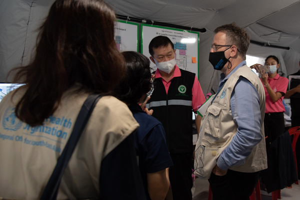Dr Rick Brown, Programme Manager Health Emergencies and AMR at WHO Thailand, visits Princess Mother National Institute on Drug Abuse Treatment (PMNIDAT) Thanyarak Field Hospital on 19 May 2021.


Thailand was the first country in the WHO South-East Asia Region to get WHO verification for its emergency medical team (EMT) in July 2019. This classification makes Thailand’s EMT the 26th in the international roster of WHO classified, internationally deployable medical teams.

To support the COVID-19 response in the country, Thailand’s EMT has adapted roles and responsibilities to provide treatment and care at a conventional hospital. The EMT supported the hospital in triage, remote treatment and care, counselling, dispensing medication and hospital referral.

The Princess Mother National Institute on Drug Abuse Treatment established a ward for the care of COVID-19 patients on 10 April 2021, supplying 34 beds for patients in need of respiratory assistance. On 22 April, it created an extended ward to make another 200 beds available and began accepting patients.

