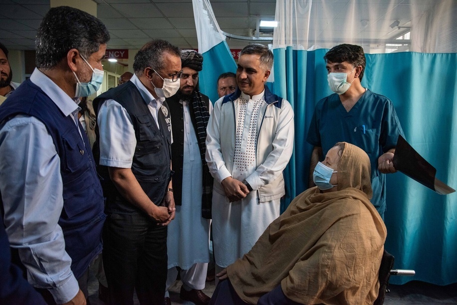 On 20 September 2021, WHO Director-General Dr Tedros Adhanom Ghebreyesus (centre left) and WHO Regional Director for the Eastern Mediterranean, Dr Ahmed Al-Mandhari (left) speak to a patient during a visit to the Wazir Mohammad Akbar Khan National Hospital in Kabul, Afghanistan. - Title of WHO staff and officials reflects their respective position at the time the photo was taken.