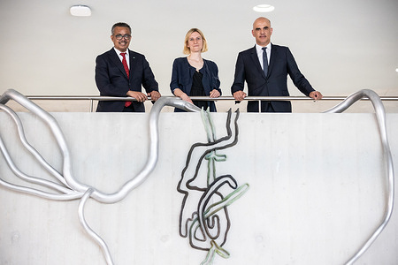 WHO Director-General Dr Tedros Adhanmon Ghebreyesus (left), Member of the Swiss Federal Council Mr Alain Berset (right) and Swiss artist Simone Holliger (centre) at the unveiling of an art donation at the World Health Organization headquarters in Geneva, Switzerland on 22 May 2022. The art piece, donated by Swiss Government, is entitled "Früchte tragen" (to bear fruits) and was conceived by the Aarau-born artist Simone Holliger. It was presented as an official bridge between the older section of the Tschumi building and its recently developed extension. Title of WHO staff and officials reflects their respective position at the time the photo was taken.