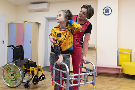 Physical Therapists Tetyana helps Sasha, 13, with physical therapy exercises. Sasha, 13, and her mother Olena moved from Kryvyi Rih to Dnipro to receive assistance for Sasha's cerebral palsy. WHO Ukraine has provided assistive technology kits (AT10 kits) with essential assistive products to health care facilities for thousands of internally displaced persons and other persons with mobility and self-care needs resulting from the war in Ukraine. Sasha received a wheelchair through the initiative.  Related:  Press release: https://www.who.int/europe/news/item/19-12-2022-who-provides-assistive-products-for-thousands-of-displaced-people-in-ukraine