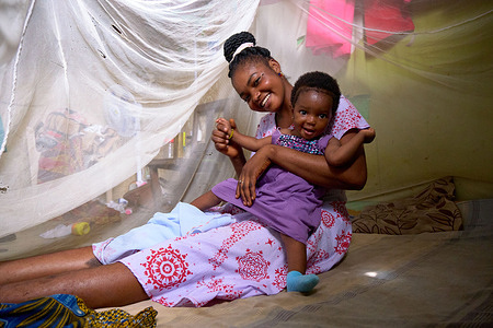 Rebecca and her child Mercy under a mosquito net at home in Gyabankrom, Central Region, Ghana. In August 2023, WHO’s Malaria Vaccine Implementation team took part in a visit across government offices, health facilities and homes in Ghana to understand how the RTS,S/AS01 malaria vaccine was being integrated into the national immunization program, and how individuals at all levels were responding to it.  Related:  https://www.who.int/initiatives/malaria-vaccine-implementation-programme