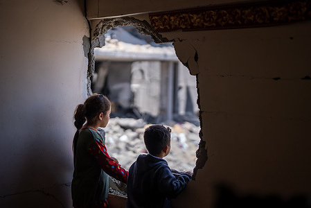 Children look out through a hole in a wall at a destroyed residential area, Gaza strip.   In the occupied Palestinian territory, where a 16-year blockade has left the Gaza Strip’s health system severely under-resourced, escalating hostilities with Israel that began on 7 October 2023 are compounding an already dire situation. Power outages and shortages of medicines and health supplies in Gaza Strip hospitals are hindering the delivery of life-saving medical care. Attacks on health care have been recorded by WHO, resulting in deaths and injuries of health workers and affecting health facilities and ambulances. As the situation revolver, there is an urgent need to establish a humanitarian corridor for unimpeded, life-saving patient referrals and movement of humanitarian personnel and essential health supplies. https://www.emro.who.int/images/stories/palestine/oPt-emegency-situation-report-issue-1.pdf https://www.emro.who.int/images/stories/palestine/oPt-emegency-situation-report-issue_2.pdf https://www.emro.who.int/images/stories/palestine/oPt-emegency-situation-report-issue_3.pdf