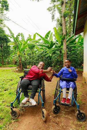 20-year-old Elizabeth (left), born with spina bifida, with her friend, 10-year-old Noreen (right), who has cerebral palsy and is a grade one pupil at Manushi Juu Primary School. Both met during their routine health checkup at Manushi Dispensary in Moshi, Kilimanjaro.