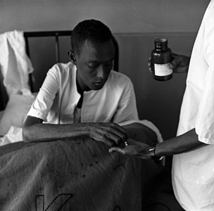 In 1959, tuberculosis is one of the mounting perils in Africa. The discovery of chemotherapy makes it possible to foresee mass treatment of TB patients without hospitalization, costing less and allowing the sick person to stay with his family and continue to work. Because patients tend to stop self-administering their drugs once they are feeling better, new drugs which need only be taken over a six-month period (instead of one year) represent a great advance in chemotherapy.