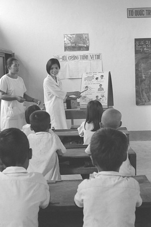 Immunization is the process whereby a person is made immune or resistant to an infectious disease, typically by the administration of a vaccine. Vaccines stimulate the body's own immune system to protect the person against subsequent infection or disease. Before carrying out smallpox vaccinations, this public health nurse gives a lecture on the disease to schoolchildren in the Republic of Viet Nam.