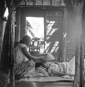 Magic to modern methods - Education of untrained midwives in modern methods of delivery, sanitation and hygiene were the object of a programme in the Philippines. Aided by WHO and UNICEF, the Philippine government launched the programme in July 1954. In ten years, some 6000 woman, about one-third of the country's hilots as the local midwives are called in Tagalog, attended 12-week courses in delivery, prenatal and postnatal care. New they were used to sending for medical assistance in the event of abnormal deliveries. They continued to work closely with local health clinics and greatly helped in the house-to-house improvement of hygiene and sanitation.Our photos show the conversion of a hilot, 58-year-old Escolastica Paeste from the village of Tamag, near Vigan on the northeast coast of Luzon. The hilot catches smoke from burning vinegar-soaked straw in a basket and gives it to the mother to breath. While smoke is inhaled by the mother, the hilot utters words against evil spirits.