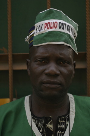 Polio immunization campaign in Nigeria Feature about immunization campaign against poliomyelitis in Nigeria. - Vaccinator with a heat in which is written "Kick polio out of Nigeria".