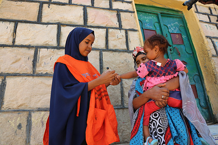 A member of a volunteer vaccination team finger marks Lina, 2, after she received double doses of the oral polio vaccine during an immunization campaign in Hargeisa, Somalia, on 19 August 2019.
