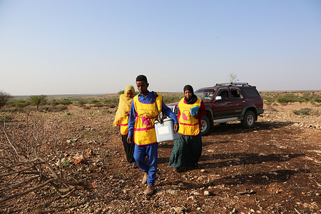 Members of the volunteer vaccination team walk though a nomadic area, 20 kilometres east of Hargeisa, Somaliia, during an immunization campaign on 20 August 2019.