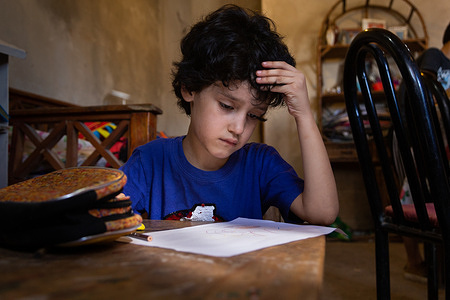 Gabriel, 7, concentrates on his drawing, an activity he enjoys and does frequently after participating in the CST programme, at his home in Moreno, Argentina, on Dec.10, 2020. Drawing is an activity implemented during the CST programme, but itÕs also a way for Gabriel to express his wants or feelings. The Caregiver Skills Training (CST) programme was developed by WHO and is being implemented in Argentina by international partner Programa Argentino para Niños, Adolescentes y Adultos con Condiciones del Espectro Autista (PANAACEA) to serve families of children with developmental delays and disabilities. The programme uses a family-oriented approach and is designed to be delivered by trained non-specialists (community-based workers, peer caregivers or others) as part of a network of health and social services for children and their families. CST consists of nine group sessions and three individual home visits, focused on training caregivers how to use everyday play and home activities and routines as opportunities for learning and development. The sessions specifically address communication, engagement, daily living skills, challenging behaviour and caregiver coping strategies. Gabriel was diagnosed with autism at age 3. He was not speaking and did not interact with other people, including his family. As a mother of four, Karina Visciglia struggled to care for her family and find Gabriel the services he needed. Through CST facilitators and PANAACEA, Karina gained access to a network of services and a support system. She saw significant improvements in her ability to connect and communicate with her son, and did so through the use of play activities, games, and home routines. She also says she felt empowered and improved herself by taking part in the group sessions. In general, caregivers of children with developmental delays often experience very high levels of distress and, in many cases, interruptions or discontinuation of care services. The COVID-19 pandemic has had major impacts on mental health but particularly on that of women and those taking care of young children with developmental disabilities. The CST programme was adapted to a remote, online version so that it was able to continue during the pandemic in Argentina.