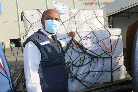 On 7 March 2021, WHO Representative to Ethiopia Dr Boureima Hama Sambo helps to receive Ehtiopia's first consignment of COVID-19 vaccine. 2.2 million doses of the AstraZeneca COVID-19 vaccine arrive at Bole International Airport in Addis Ababa, Ethiopia. The delivery was facilitated by the COVAX mechanism and marks the start of the country’s COVID-19 vaccination campaign, which launched on March 13. “The arrival of the vaccines in Addis Ababa is a major milestone, a turn of the tides for the better, in the response to the COVID-19 pandemic, thanks to the coordinated global action for equitable vaccine distribution,” Dr Boureima Hama Sambo, WHO Representative in Ethiopia, said. “WHO will continue to work with the Government of Ethiopia and global partners to ensure that Ethiopia receives, deploys and administers adequate quantities of COVID-19 vaccines to the Ethiopian people, because as WHO has repeatedly said, no one is safe until everyone is safe.” COVAX, the vaccines pillar of the Access to COVID-19 Tools (ACT) Accelerator, is co-led by the Coalition for Epidemic Preparedness Innovations (CEPI), Gavi, (the Vaccine Alliance) and the World Health Organization (WHO) – working in partnership with developed and developing country vaccine manufacturers, UNICEF, the World Bank, and others. It is the only global initiative that is working with governments and manufacturers to ensure COVID-19 vaccines are available worldwide to both higher-income and lower-income countries. Title of WHO staff and officials reflects their respective position at the time the photo was taken.