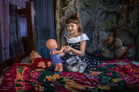 Nadiia, 9, plays with her dolls during a home visit by members of the WHO-supported mobile mental health team with Nadiia's mother Nataliia, 39, a former patient, on February 15, 2021 in Bylbasivka, Ukraine. The COVID-19 pandemic and protracted conflict along the Ukraine-Russian border have had a devastating impact on Ukrainians with severe mental health conditions. These coinciding events have further limited their access to specialized care. Introduced by WHO in 2015, the community mental health teams project originally aimed to provide comprehensive community-based mental health care to people who faced consequences of the conflict. In 2020 WHO has reinforced its support to Ukraine in the area of mental health as a part of WHO Special Initiative for Mental Health, and seven community mental health teams are working across Ukraine during the COVID-19 pandemic. Community-based care is a new approach for mental health care in Ukraine but with the support from WHO, Ukraine aims to scale up the teams for people with severe mental health conditions throughout the country. A team based in Slovyansk and consisting of a psychiatrist, a psychologist, a nurse and a social worker travel to different settlements in the region to deliver specialized mental health care to their patients. The team helps the person to develop their recovery plan, cope with symptoms of mental health conditions and prevent crisis, supports them in maintaining activities of daily living and social relations, engages resources available in community for education, housing, employment and social protection.
