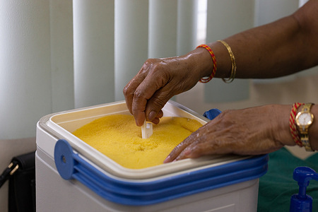 The sanitized hands of Rajwantee, a registered nurse, carefully remove a measure of the vaccine from the cooler. The vaccine will be administered to “the recipient” at the Siparia District Health Facility in Trinidad and Tobago, as part of a vaccination drill conducted on 6 March 2021. As Trinidad and Tobago prepare for their initial delivery of 100,000 to 120,000 doses of the Oxford-AstraZeneca COVID-19 vaccine, a key strategy in preparing and training the healthcare workforce is the use of simulation exercises. This includes the use of different simulation exercises, including discussion based table-top exercises as well as more operational based exercises such as drills. They are used to assist in developing, assessing and testing the functional capabilities of emergency systems, procedures and mechanisms to respond to public health emergencies. COVID-19 vaccine simulations test planning assumptions and procedures in a safe and constructed environment before national vaccine roll-outs occur. These simulations help to ensure that vaccine roll-outs have the best possible chance of success. Using simulations developed by WHO and COVAX, health workers in Trinidad and Tobago are able to test and practice the planning and logistics of vaccine administration within the specific context of their country. Participants in these exercises are personnel who perform their actual responsibilities and respond as they would in a real situation. They can practice their role within the vaccine roll-out at every stage and identify where the plan and procedures are working well and where it could be improved. During the vaccination drill conducted at the Siparia District Health Facility in Trinidad, multiple scenarios were simulated at once to test preparedness including: a recipient who was fully decided to take and receive the vaccine, a recipient who was undecided, walk in recipients with no appointments, a recipient with severe reaction, and a recipient who declined being vaccinated.