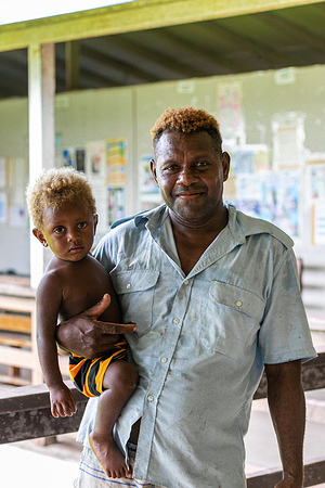 Patient John and his son leave the Tulagi Clinic outpatient area in Tulagi, Solomon Islands on 5 March 2021. - In Solomon Islands, WHO recognised that health systems needed to develop to accommodate a rise in noncommunicable diseases or NCDs in the region. Previously, health programs were mostly designed to treat patients with acute conditions or diagnosis. However, the increase of NCDs like cardiovascular disease, diabetes, cancer and chronic lung diseases pose a grave threat to regional and national health and development. Working hand in hand with the Ministry of Health and the provincial governments, WHO helped design a program that would respond to the rise in NCDs in the region. The program aims to provide better overall care for patients, including screenings as well as prevention and treatment of NCDs, primarily cardiovascular diseases related to diabetes, hypertension, obesity, etc. Known as the PEN (Package of Essential Noncommunicable Disease Interventions) program, this approach considers the patient's whole being and lifestyle, not just specific ailments, and emphasises wellness and prevention activities. Additionally, WHO promotes integration of multiple health services, and the PEN program integrates TB (Tuberculosis) screenings as it screens for NCDs. The PEN program was started at WHO headquarters in Honiara but is now led by provincial NCD coordinators who have taken ownership of the program. Virginia Legaile, based in Tulagi (about a 1.5 hour boat ride from Honiara), is one of these provincial NCD coordinators. She previously worked as a nurse in an outpatient clinic, but after embracing the NCD screening of patients that was incorporated as part of the PEN program, the medical director increased her hours to see NCD patients from one to five days a week. Virginia is one of twelve NCD Coordinators across the country who, along with her peers, has also started the first paper medical file system in the entire country.
